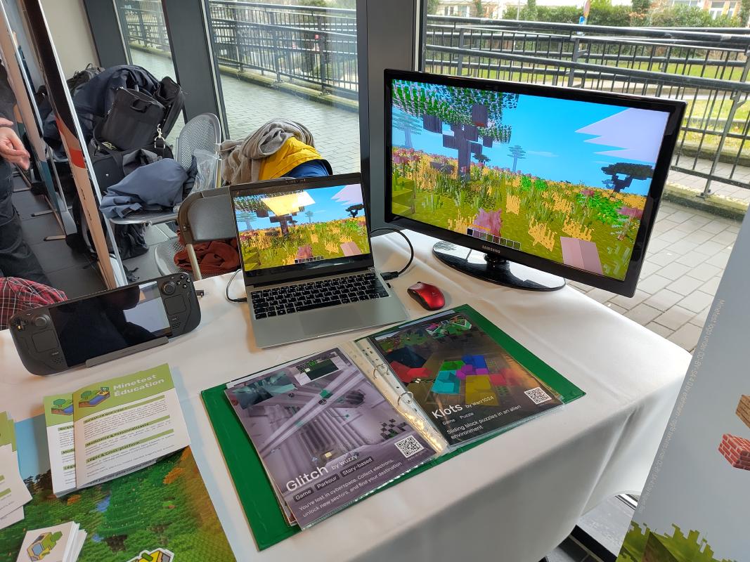 Minetest running on a laptop, with a booklet showcasing some games made on it in front.